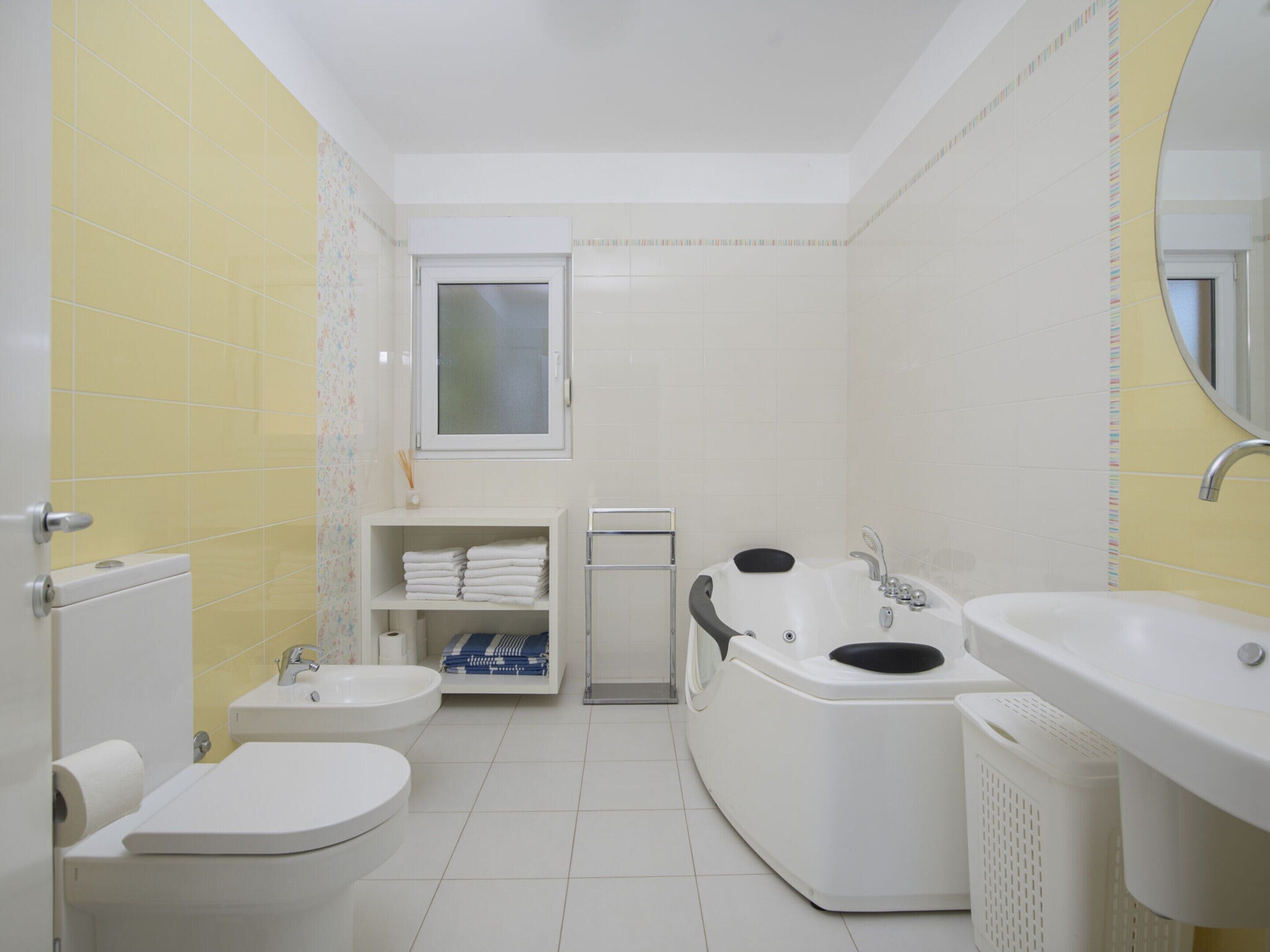 Een badkamer met toilet, bidet, bad en wastafel.