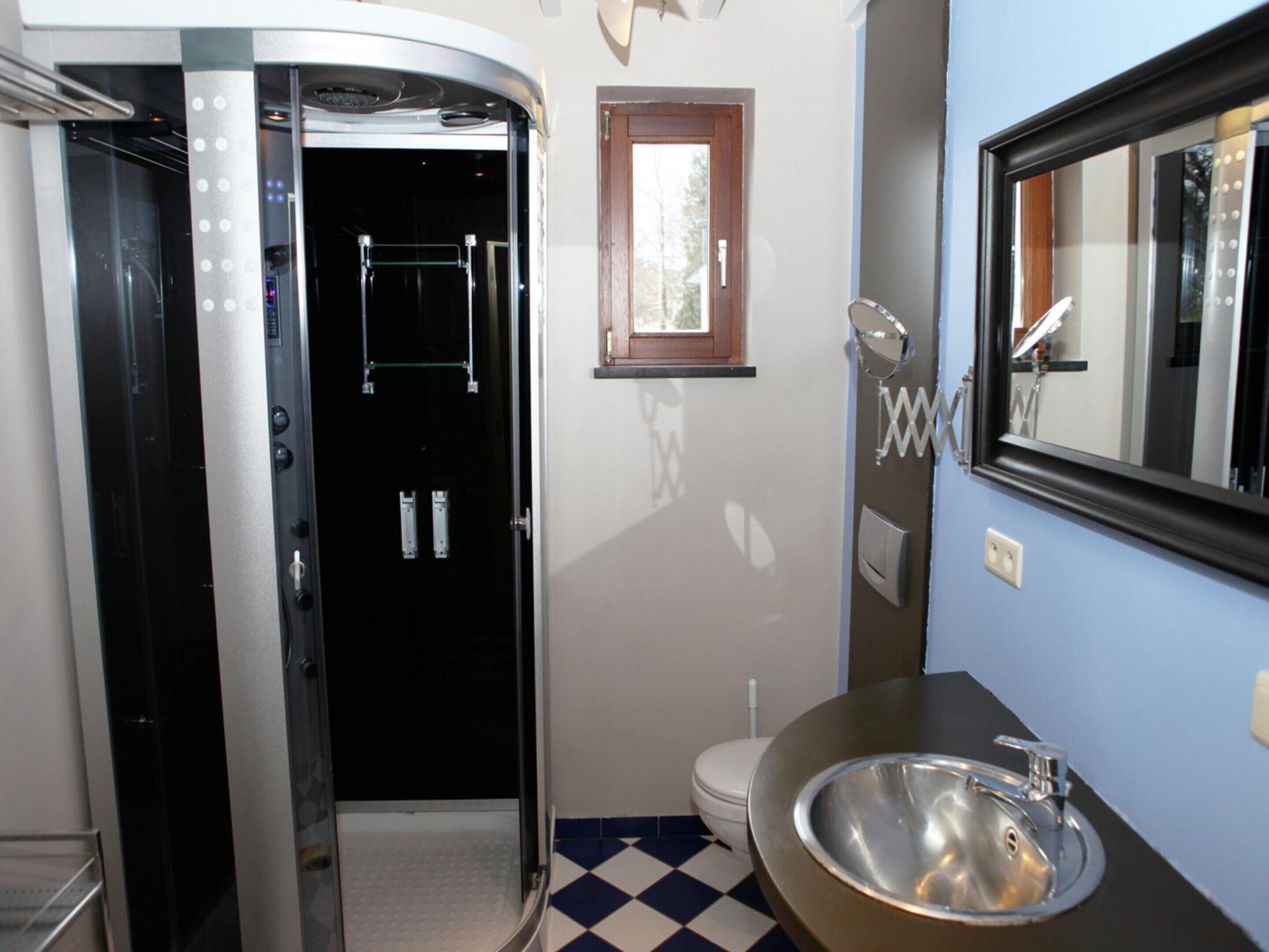 A bathroom with a shower, toilet, and sink.