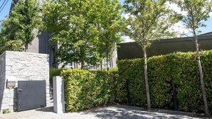 A paved courtyard with a stone wall, a metal gate, and a hedge. - Holiday Home in Denee for 21 People (Anhée)