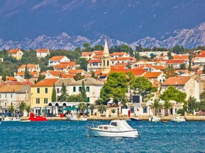 A coastal town with colorful buildings, a prominent church, and boats in the water.