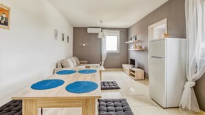 Een moderne keuken met een eettafel, een koelkast en een bank.