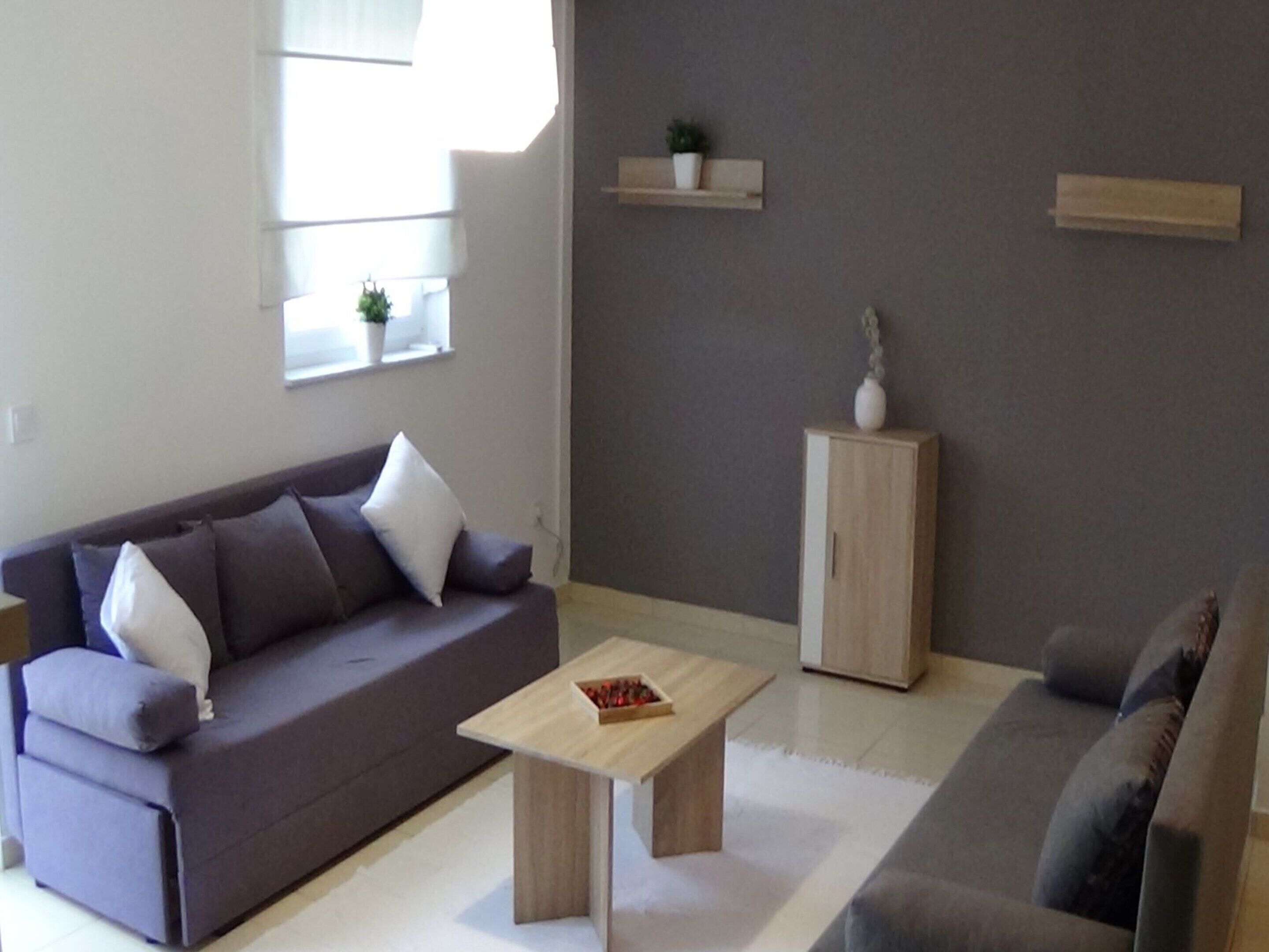 A modern living room with a grey sofa, a wooden coffee table, and a cabinet.