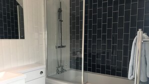 Een bad/douchecombinatie, handdoeken