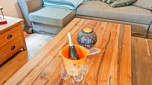 A wooden coffee table with a bottle of champagne and several glasses. - Scenic Stay in Xhoffraix (Malmedy)