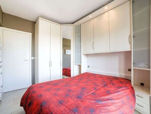 A bedroom with a bed, white wardrobe, and a mirror. - Simplistic Apartment in Blankenberghe near Belgium Pier (Blankenberge)