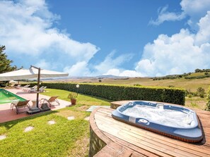 A hot tub on a wooden deck with a view of rolling hills and a clear sky. - Belvilla by OYO San Francesco Vermentino (Lajatico)