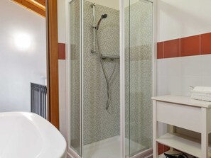 A modern bathroom with a glass-enclosed shower, a white sink, and a tiled wall with a red accent. - Belvilla by OYO Vega (Caprino Veronese)