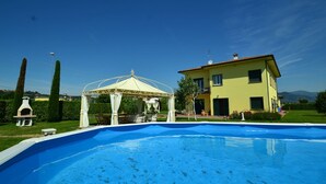 A swimming pool with a gazebo, a yellow house, and a clear blue sky. - Villa in Montecarlo With Pool and Scenic Views (Montecarlo)