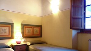 A bedroom with two single beds, a nightstand with a lamp, and a small cabinet. - Holiday Home in Montecarelli With Pool (Barberino di Mugello)