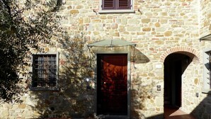 A stone building with a central door, a small window, and an arched entrance. - Holiday Home in Montecarelli With Pool (Barberino di Mugello)