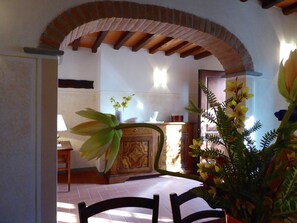 Experience the warmth of a traditional space with a vaulted ceiling, ornate cabinet, and a potted plant.