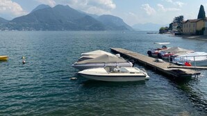 A marina with boats docked, a wooden pier, and mountains in the background. - Sunny & Peacefully Situated House near Center of Village (San Siro)