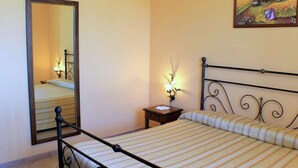 Ein Schlafzimmer mit Bett, Nachttisch, Spiegel und einem Bild an der Wand.