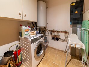 A laundry area with a washing machine, a water heater, and a baby changing station. - Bertrix Charming 2-bedroom Holiday Home (Bertrix)