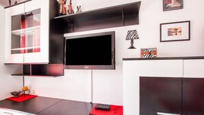 A modern kitchen with a flat-screen TV, built-in cabinets, and decorative items. - Refreshing Apartment in Omis With Balcony (Omis)