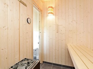 Ein rustikales Interieur mit einem Steinkonstruktion als Waschbecken, einer Uhr und einer Wandleuchte.