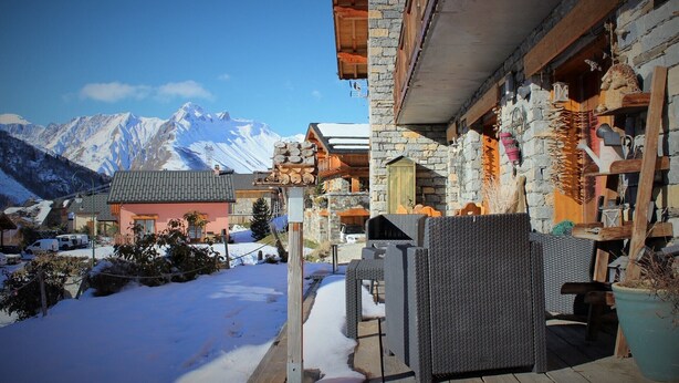 A mountain lodge with stone walls, wooden balconies, and a view of snow-covered peaks. - Chalet Chocolat chaud 4 rooms - 90m², sleeps 7 in the heart of Belleville (st martin de Belleville)