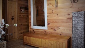 A wooden cabin interior with a bench, a mirror, and a wall-mounted light fixture. - Chalet Chocolat chaud 4 rooms - 90m², sleeps 7 in the heart of Belleville (st martin de Belleville)