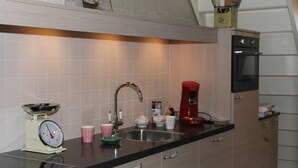 A kitchen with a sink, a coffee maker, a scale, and a cabinet. - Nice Vacation Home in Horssen With Garden (Horssen)