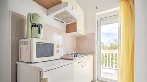 A compact kitchen with a microwave, coffee maker, and a small sink. - Elegant Apartment in Banjole near Fratarski Otok Island (Medulin)