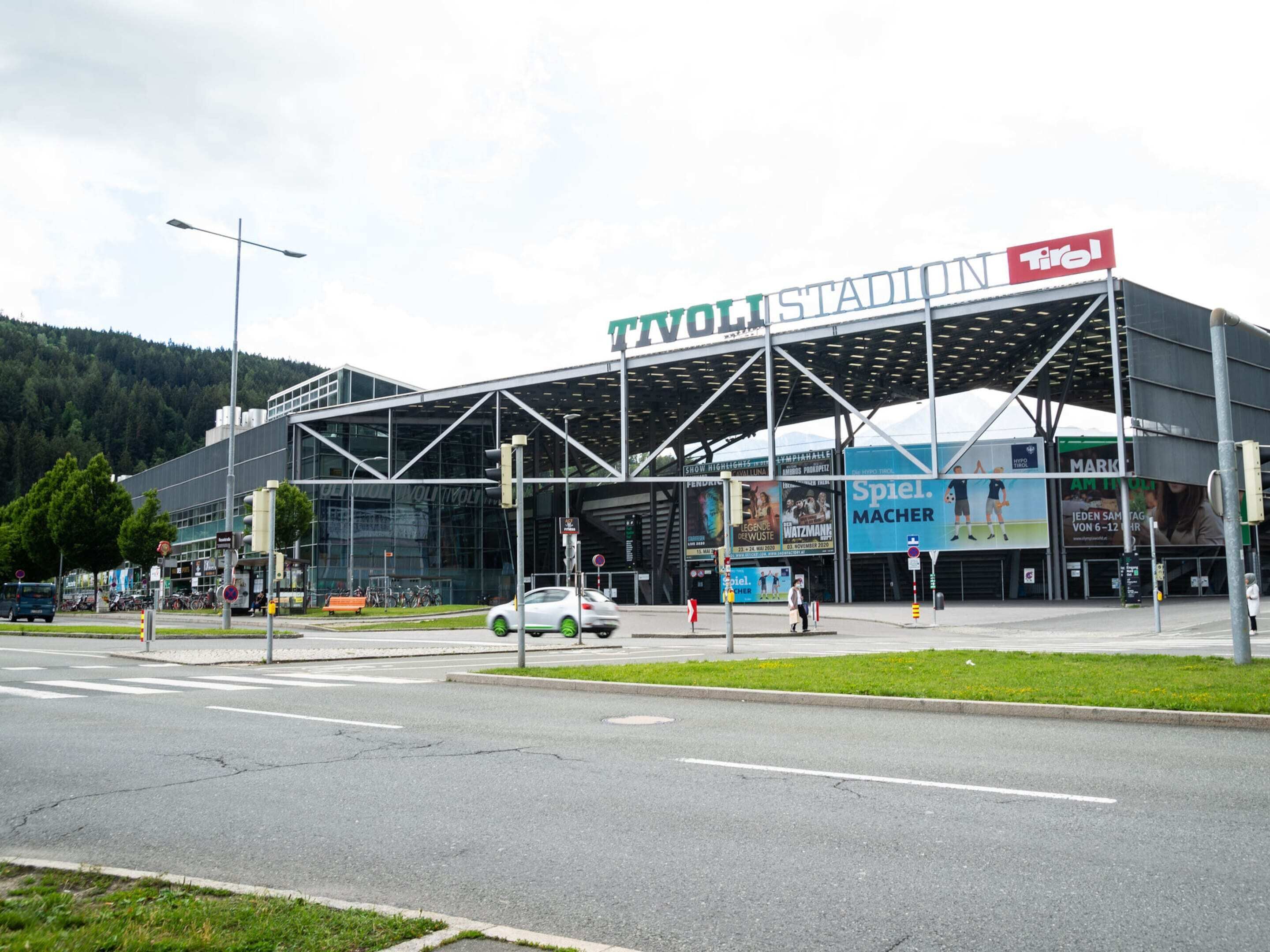 Een modern stadion met een grote glazen gevel en een opvallende dakconstructie.