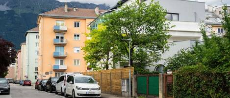Une rue bordée de voitures garées et d’immeubles à plusieurs étages.