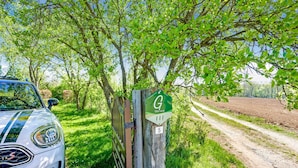 A white car parked next to a wooden gate with a green sign labeled "Gîte rural" and the number 5. - Holiday Home in Porcheresse Daverdisse (Daverdisse)