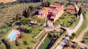 An aerial view of a rural property with a swimming pool, a small pond, and terraced fields. - Belvilla by OYO Fienile (Castelfiorentino)