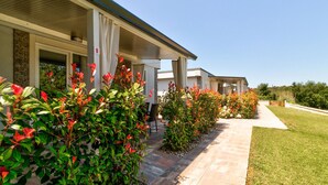 A row of hotel rooms with a covered walkway, each room having a door with a number. - Mobile Home in Banjole Near Beach (Medulin)