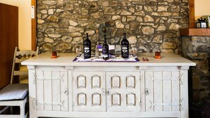 A stone wall backdrop with a white bar counter displaying bottles and glasses. - Lovely Cottage in Vierves-sur-viroin With Garden and Terrace (Viroinval)