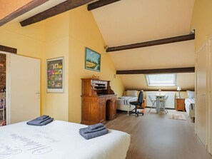 Una camera da letto con un letto, una scrivania, una sedia, un termosifone e una finestra.