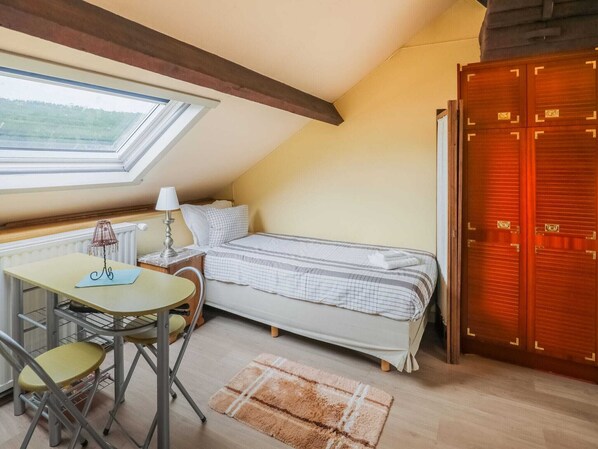 A small, cozy room with a bed, a desk with a chair, a lamp, and a large window. - Lovely Cottage in Vierves-sur-viroin With Garden and Terrace (Viroinval)