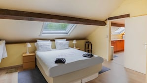 A bedroom with a skylight, a bed with pillows, a bedside table, and a nightstand. - Lovely Cottage in Vierves-sur-viroin With Garden and Terrace (Viroinval)