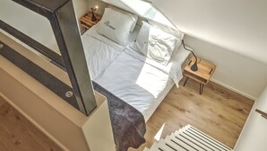 A bedroom with a bed, white bedding, a nightstand, a lamp, and a skylight. - Tranquil Farmhouse in Rijsbergen With Hot Tub and Garden (Rijsbergen)