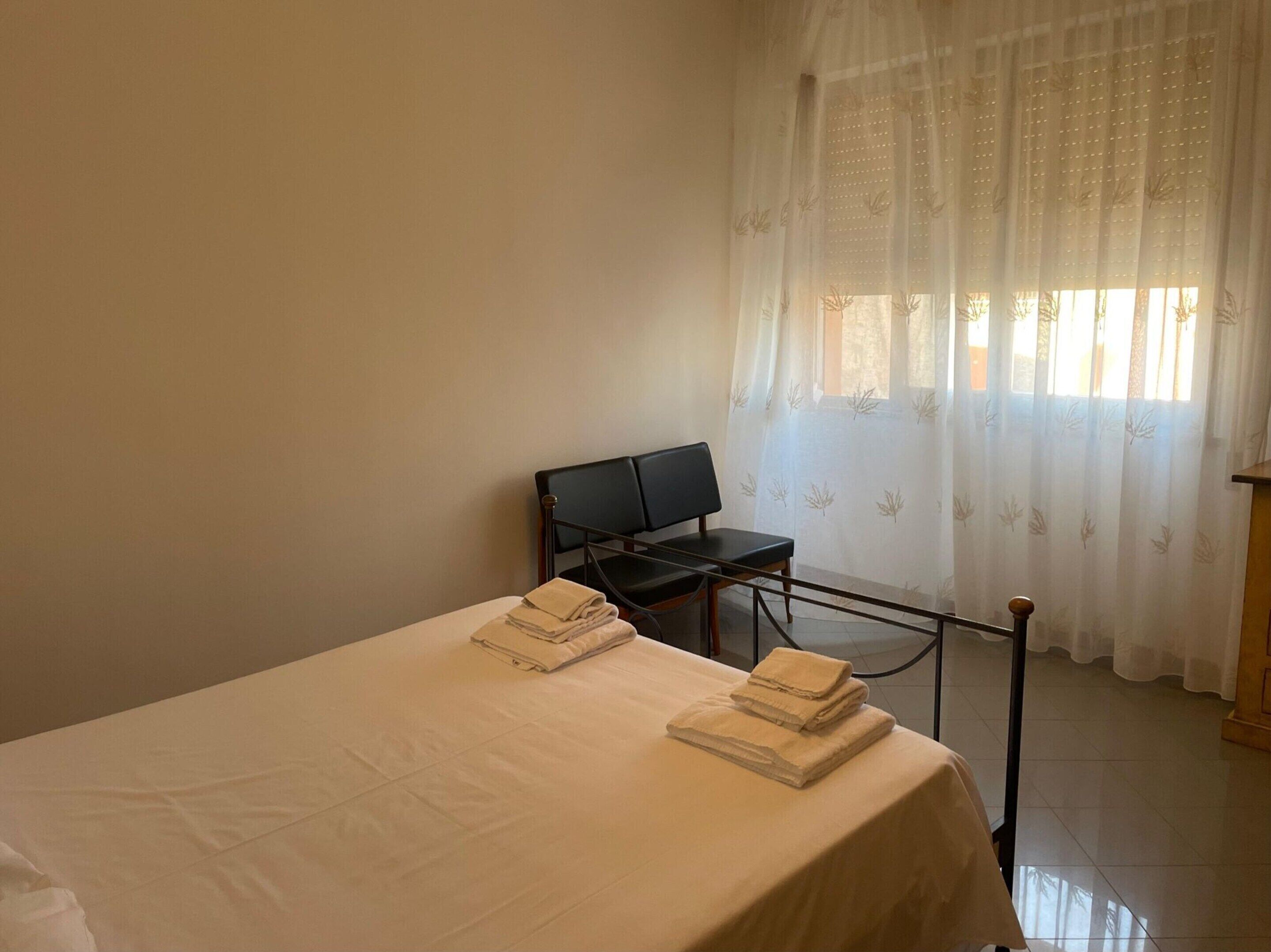 A hotel room with a bed, a desk, and a chair.