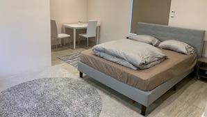 Une chambre à coucher moderne, avec un lit, un bureau et une chaise.