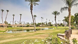 Un campo da golf con uno stagno, palme e prati curati.
