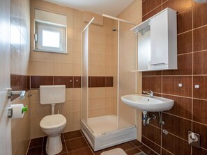 A bathroom with a toilet, shower, sink, and a cabinet. - Lovely Apartment in Novalja near Sea Beach & Town Center (Novalja)