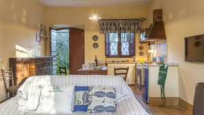 Quarto compacto com cama, mesa de jantar, cozinha e um pequeno espaço de estar.