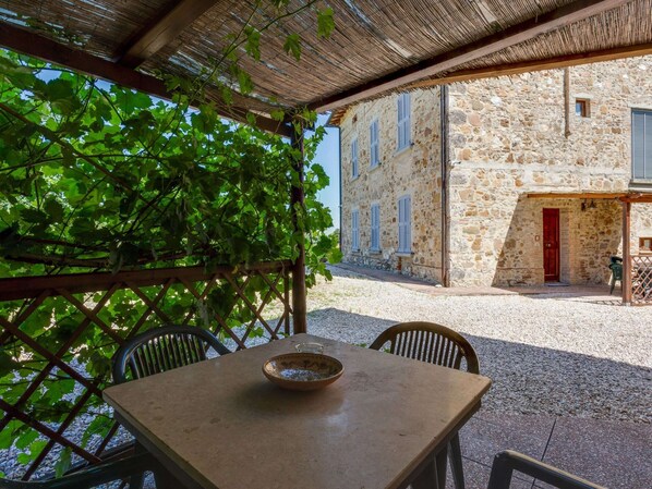 A stone building with a thatched roof patio area.