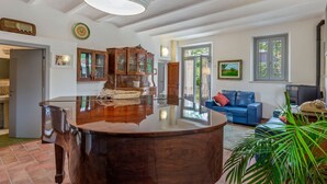 A spacious living area with a large wooden coffee table, a blue sofa, and a cabinet with glass doors.
