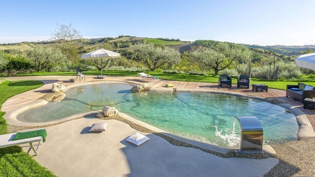 A pool area with lounge chairs, umbrellas, and a view of rolling hills. - Holiday Home in Fermo Near Porto San Giorgio (Fermo)