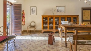 A dining area with a wooden table, chairs, and a cabinet with glass doors. - Holiday Home in Fermo Near Porto San Giorgio (Fermo)
