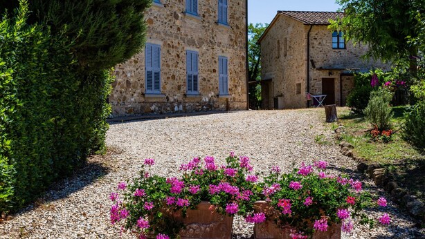 A stone building with multiple windows and a gravel driveway. - Tuscan Countryside Stay (Casole d'Elsa)