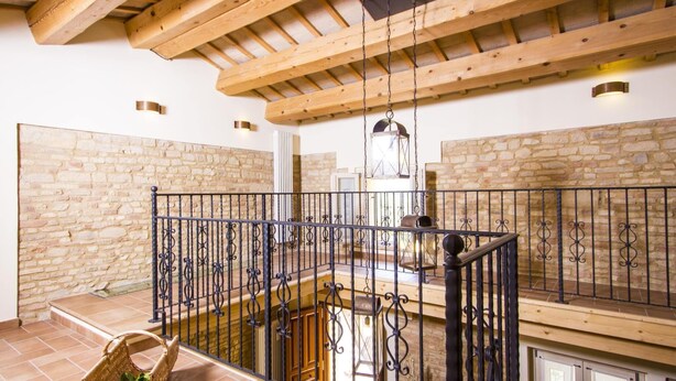 A spacious balcony with a wrought iron railing, stone walls, and a wooden ceiling. - Holiday Home in Fano Near the Sea (Fano)