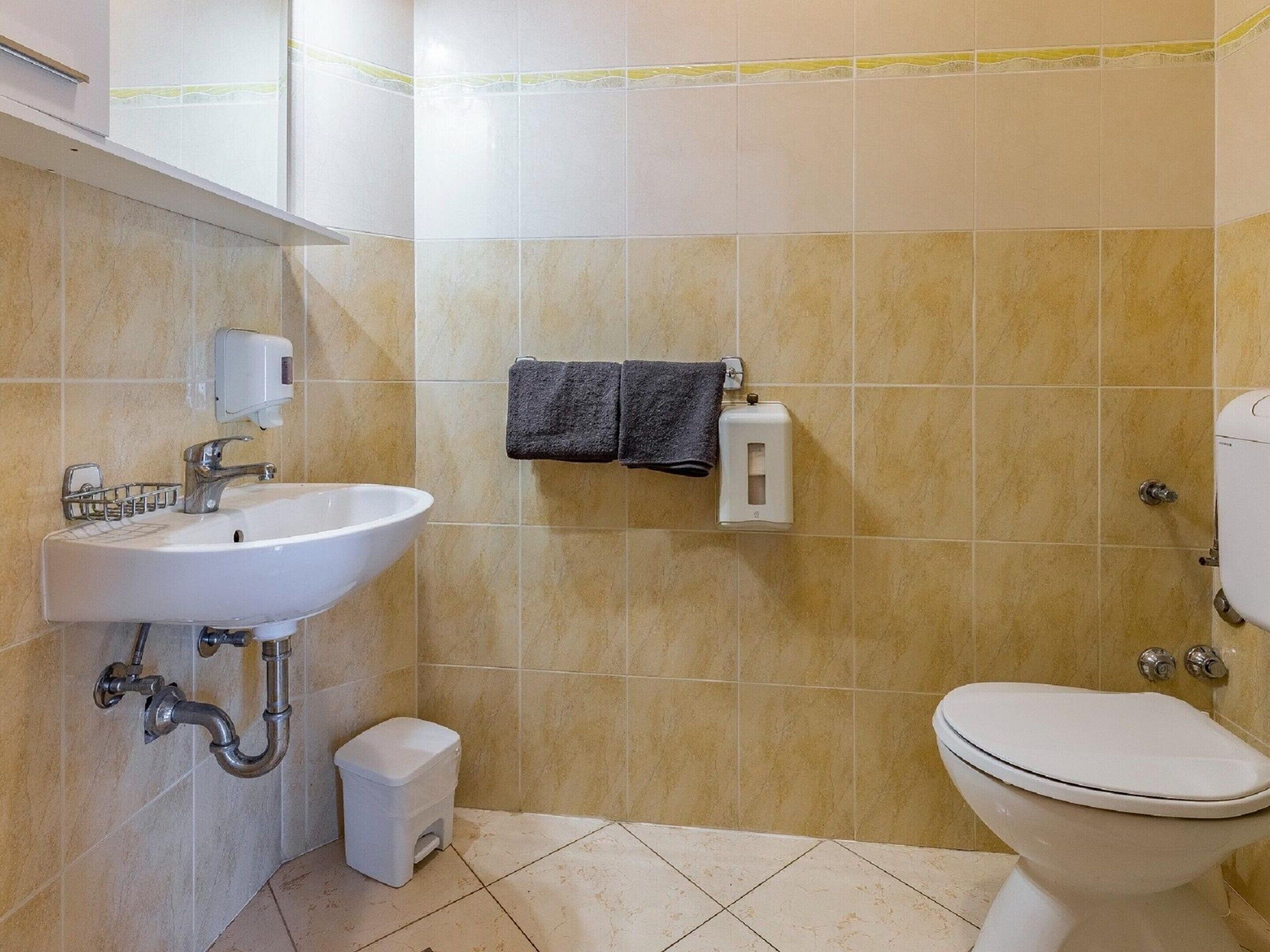 Ein Badezimmer mit Waschbecken, Toilette und Handtrockner.