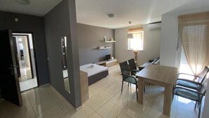 A modern, well-lit apartment with a dining area, a small kitchenette, and a living space. - Apartment in Novalja Near Pag Beaches (Novalja)