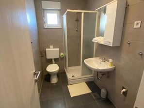 A bathroom with a toilet, sink, and shower.