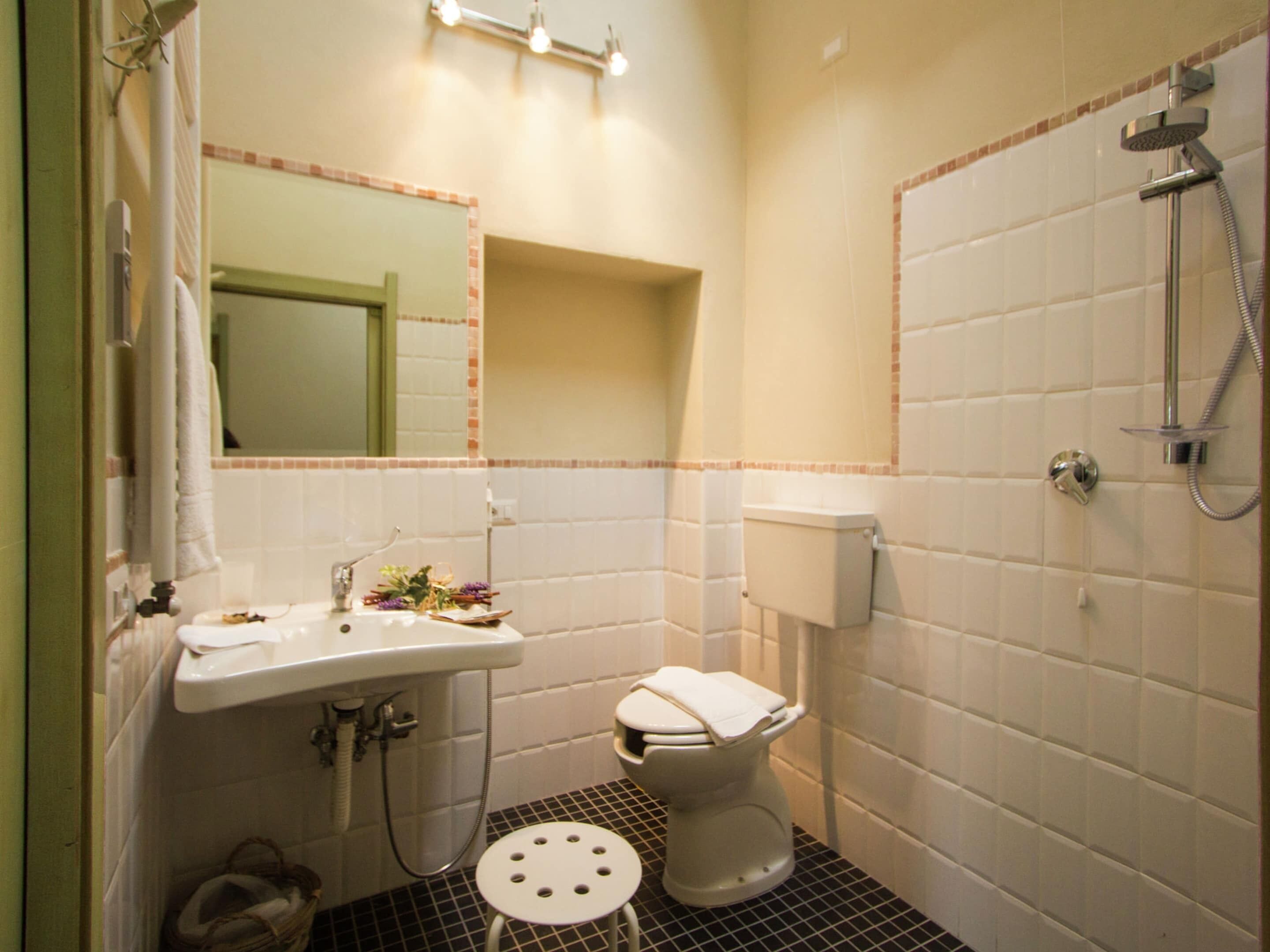 A compact bathroom with a sink, toilet, and shower.