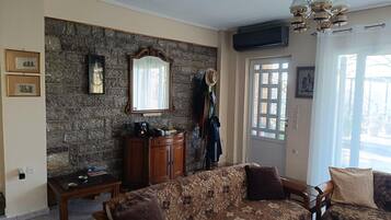 A living room with a stone wall, a wooden cabinet, a sofa, and a door with a window.